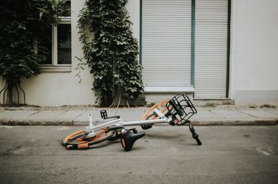 Abandoned toy car on street against building
