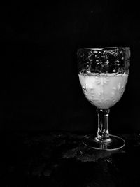 Close-up of wineglass against black background