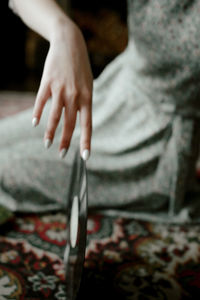 Close-up of woman sitting on bed at home