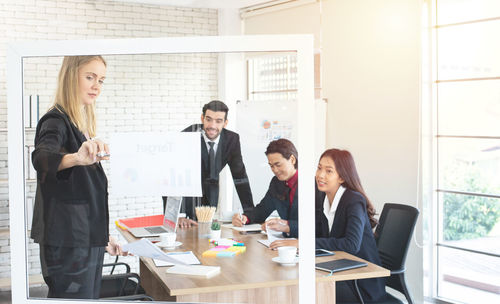 Cheerful businesswoman giving presentation in office