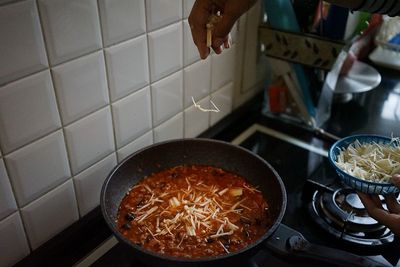 Cropped hand preparing food in kitchen