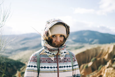 Portrait of young man standing against mountain