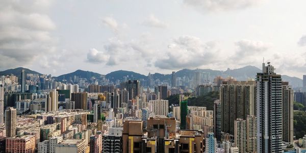 Aerial view of buildings in city against sky