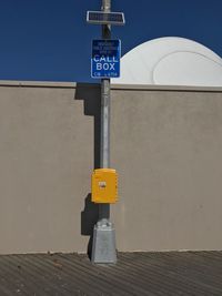 Close-up of road sign against clear blue sky