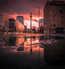 Reflection of buildings in city at sunset