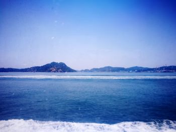 Scenic view of sea against clear blue sky