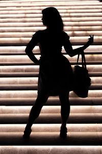 Rear view of silhouette woman against wall