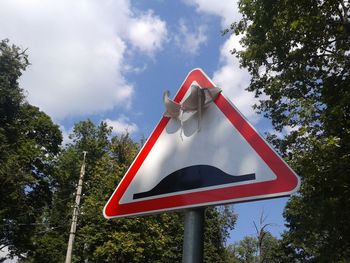 Low angle view of road sign against sky