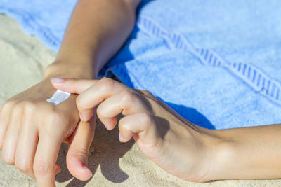 Cropped hands of woman applying sunscreen