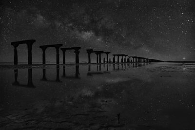 Built structure on sea against sky at night