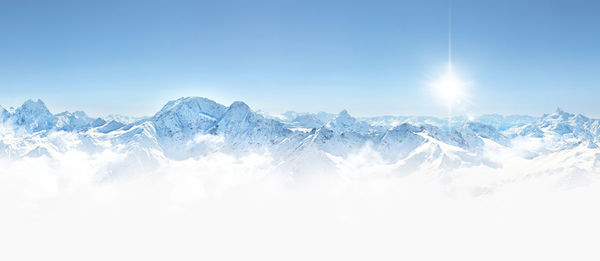 Scenic view of snowcapped mountains against blue sky