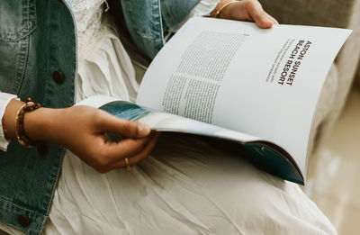 Midsection of woman reading book