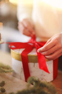 Close-up of woman holding red chili peppers in box