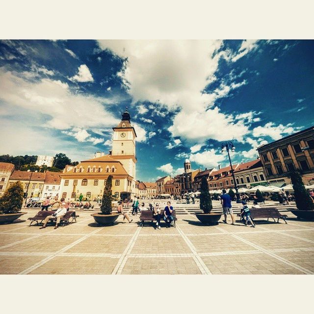 architecture, building exterior, built structure, sky, street, transportation, land vehicle, car, city, transfer print, men, mode of transport, large group of people, person, city life, cloud - sky, road, walking, city street