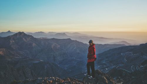 Portrait of woman standing on mountains against sky during sunset