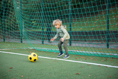 A little boy plays soccer on the soccer field