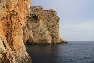 Rock formations in sea against sky