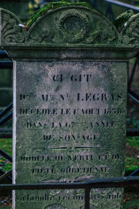 Close-up of text on rusty metal at cemetery