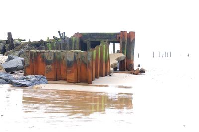 Built structure on beach against clear sky