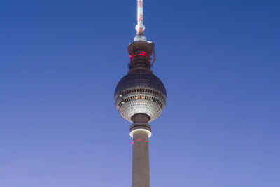 Low angle view of communications tower against blue sky