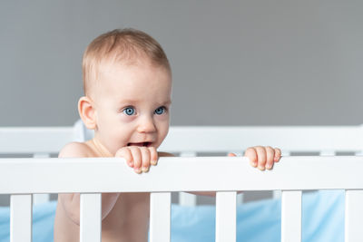 Portrait of cute baby boy lying on bed