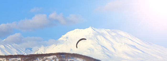 Paraglider flying against the background of volcano on kamchatka peninsula