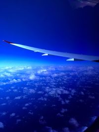 Aerial view of aircraft wing over clouds