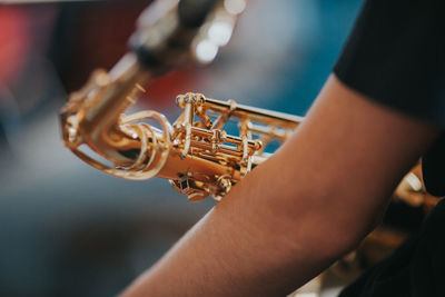 Midsection of man playing saxophone