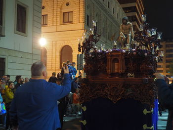 Rear view of people on illuminated building at night