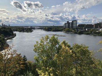 Scenic view of river by buildings against sky