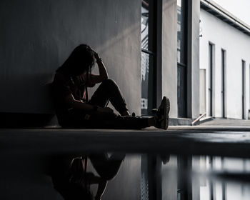 Woman sitting by window in building