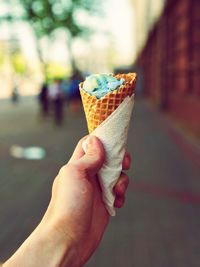 Close-up of hand holding ice cream cone