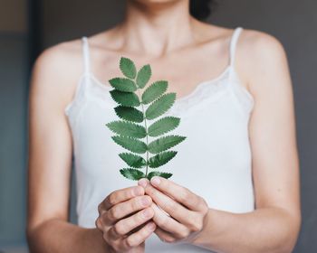 Midsection of woman holding plant