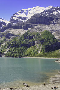 Scenic view of lake by mountains against sky