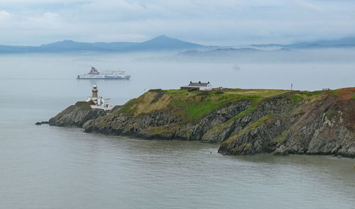 Scenic view of sea and mountains against sky