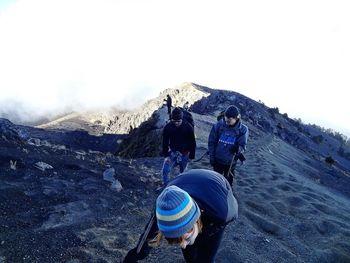 People hiking on snow covered mountain