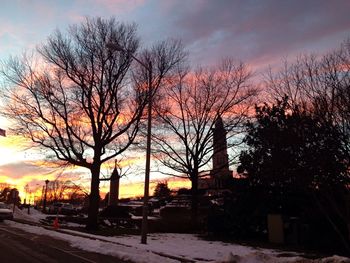 Silhouette trees against dramatic sky during sunset