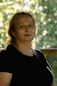 Portrait of elderly woman close-up on natural background. sunset light on face of senior