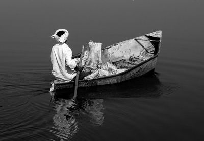 Rear view of man sailing boat in lake