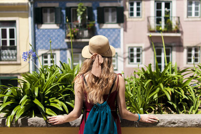 Rear view of woman walking by plants