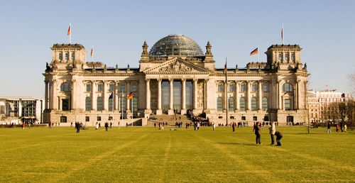 People in front of historical building against sky