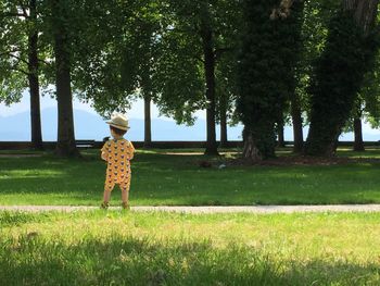 Rear view of boy standing on field