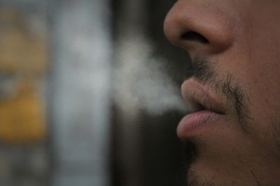 Close-up of man exhaling smoke