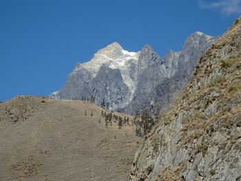 Scenic view of mountains against blue sky