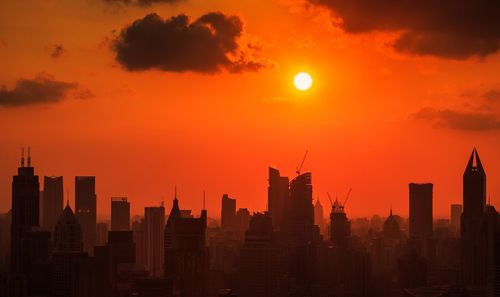 Cityscape against orange sky at sunset