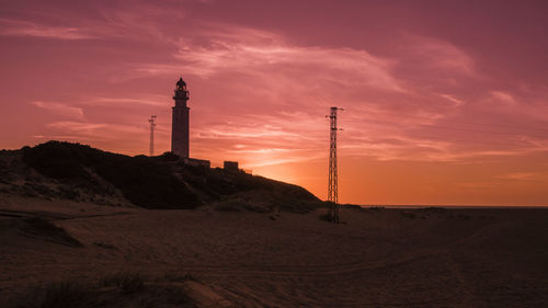 Low angle view of silhouette lighthouse against sky during sunset