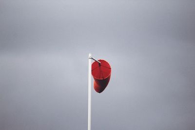 Low angle view of red flag against sky