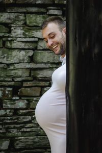 Portrait of smiling man standing against wall