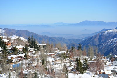 Houses in town against clear sky during winter