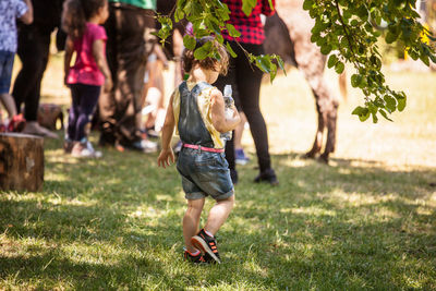 Low section of women walking on field